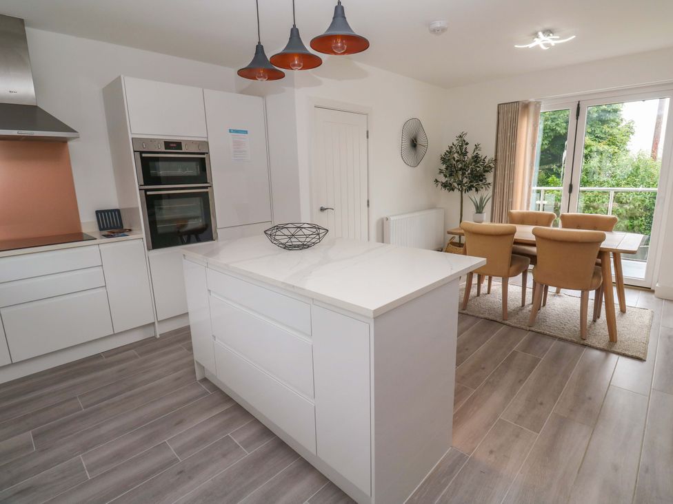 A kitchen with an island and dining area at Miramar in St. Ives