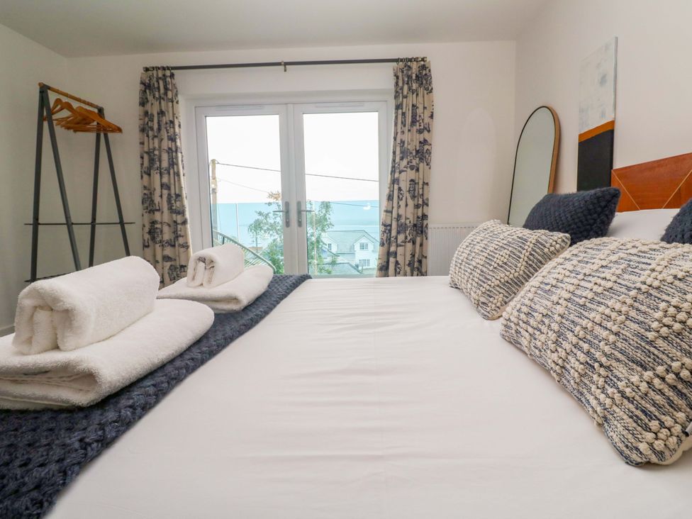 A bedroom with a bed and towels at Miramar St. Ives
