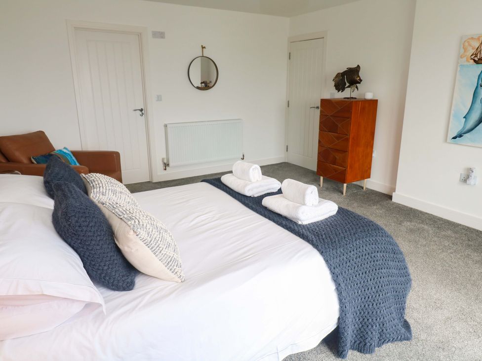 A bedroom with a bed and a chair at Miramar in St. Ives