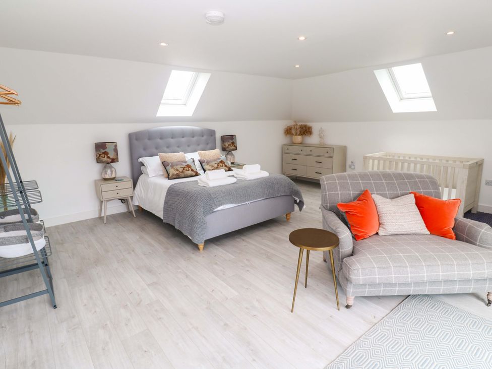 A bedroom with a bed and sofa at Miramar in St. Ives