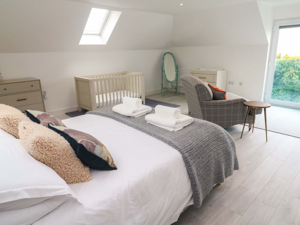 A bedroom with a crib and a dresser at Miramar in St. Ives