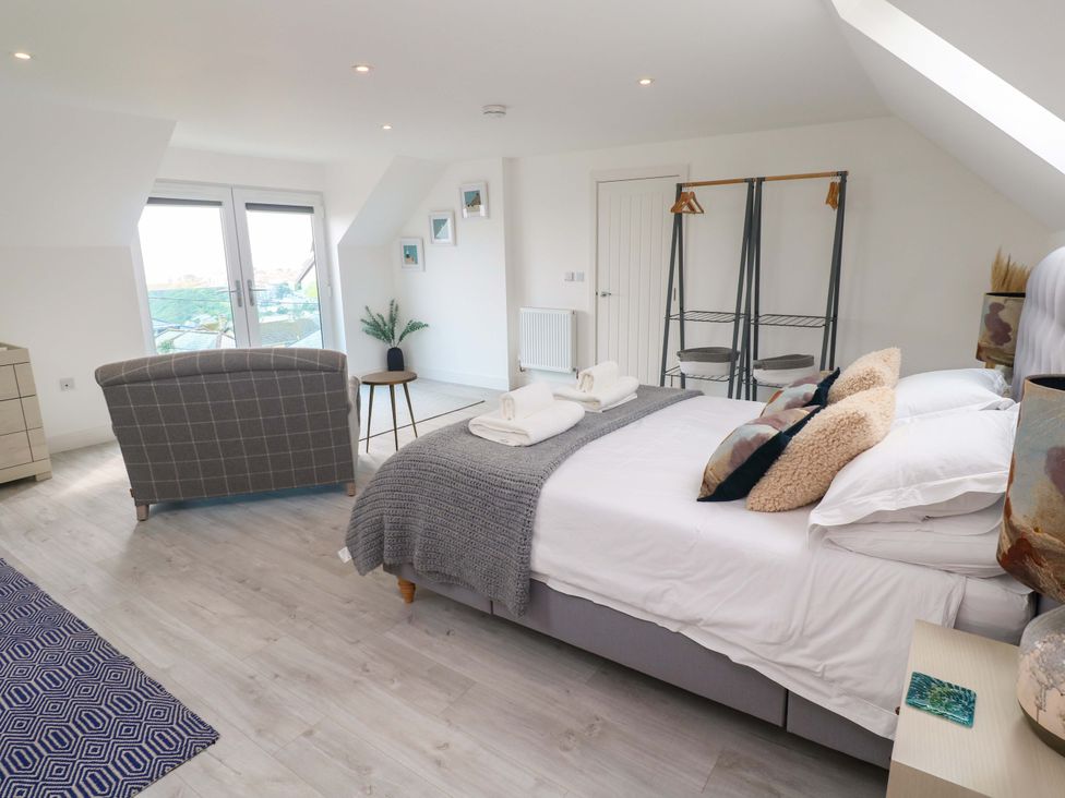 A bedroom with a bed and seating area at Miramar in St. Ives