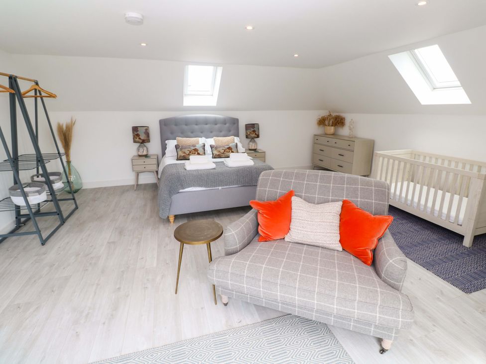A bedroom with a bed and a crib at Miramar in St. Ives