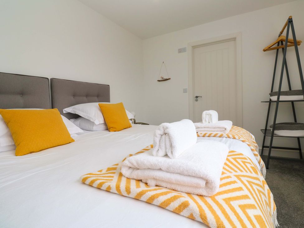A bedroom with a bed and towels at Miramar St. Ives