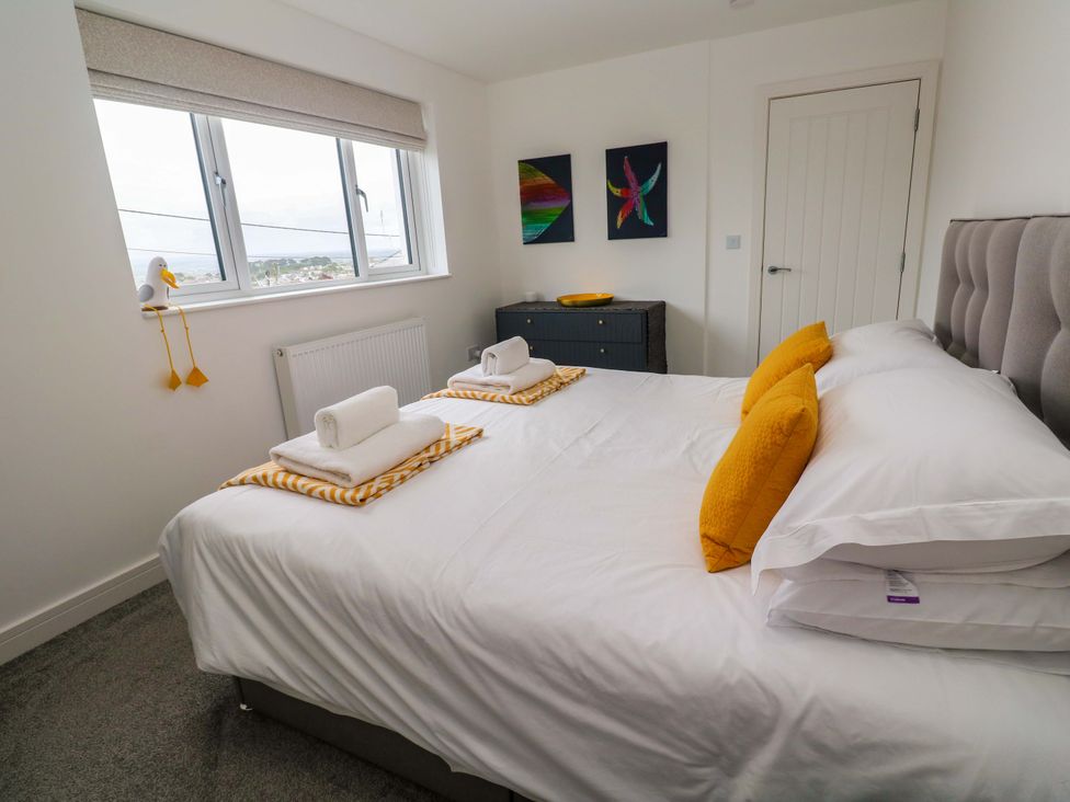 A bedroom with a bed and artwork at Miramar in St. Ives