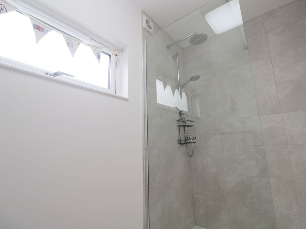 A bathroom featuring a shower with glass enclosure and a window at Miramar St. Ives