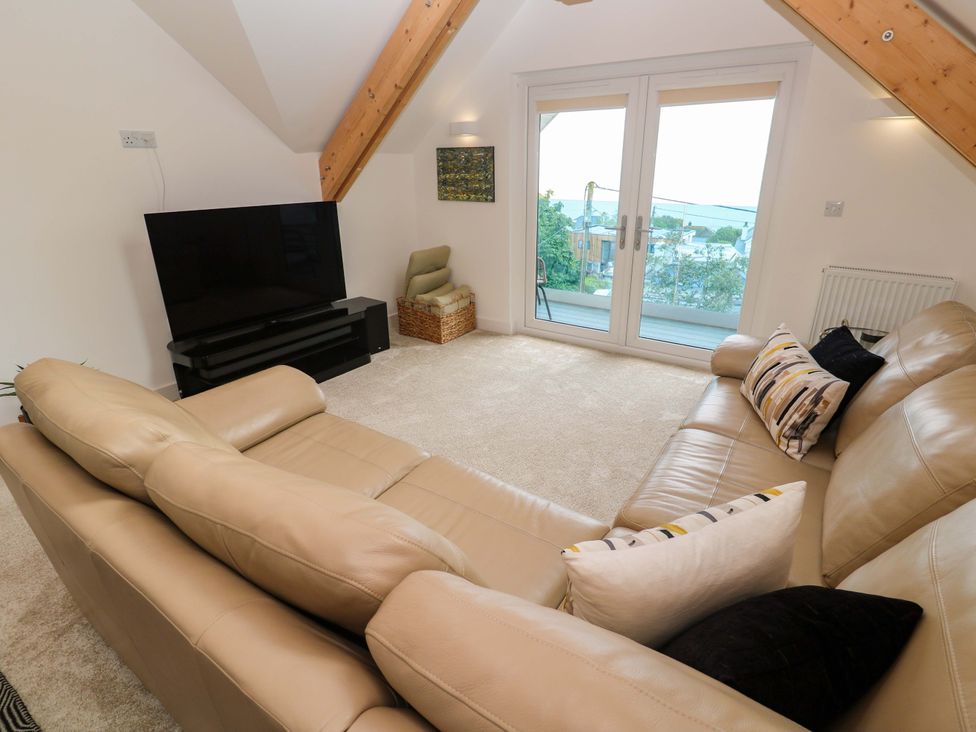A living room with a tv and sofa at Miramar in St. Ives