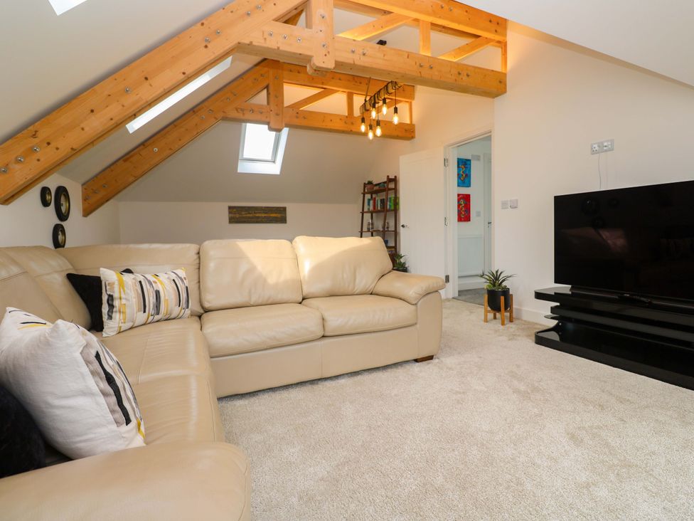 A living room with a sofa and television at Miramar in St. Ives