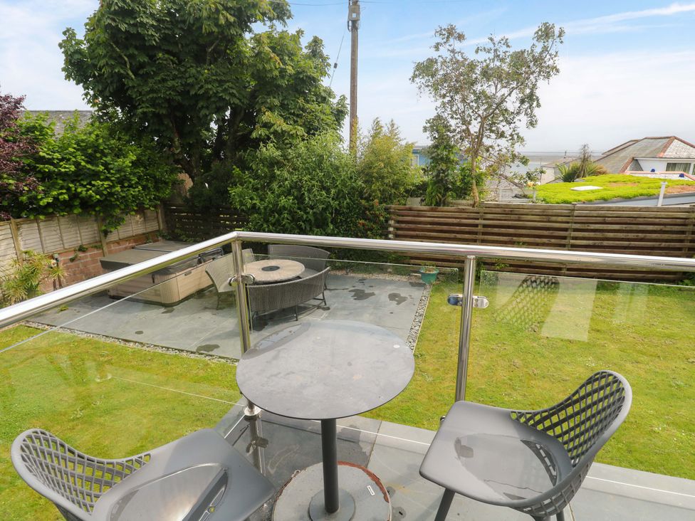 A balcony overlooking a garden with a table and chairs at Miramar in St. Ives