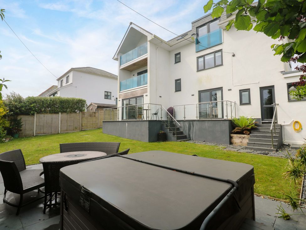 A garden with a house and patio furniture at Miramar in St. Ives
