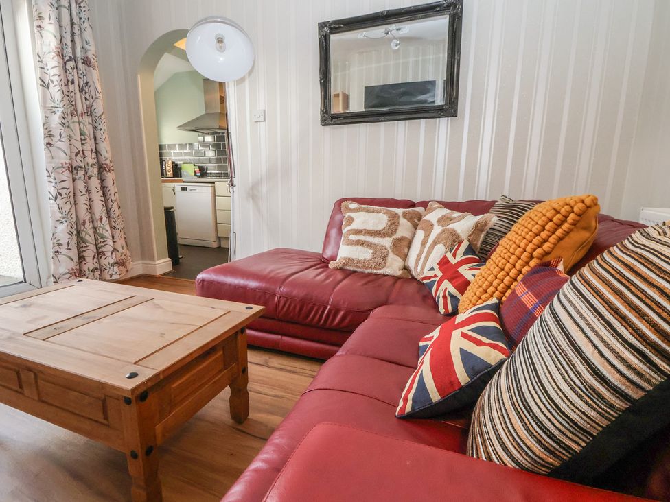 A living room with a red sofa and coffee table at 57 Broadway West in Chester