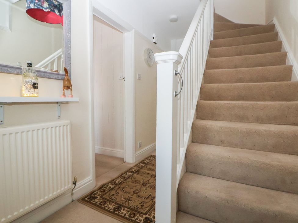 A hallway with stairs and a decorative mirror at 57 Broadway West Chester