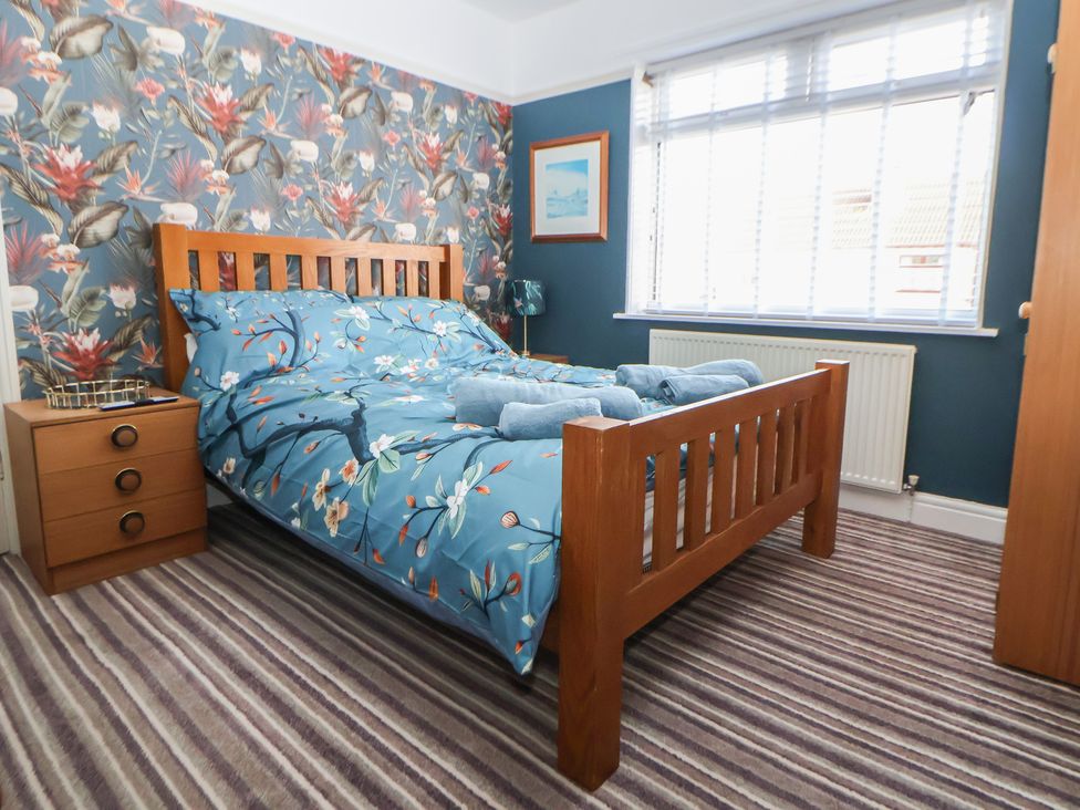 A bedroom with a wooden bed and blue bedding at 57 Broadway West in Chester