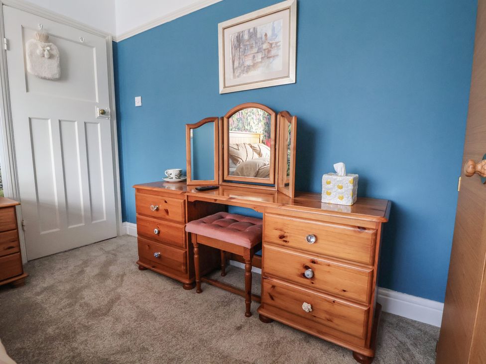 A dresser with a mirror and chair in a bedroom at 57 Broadway West in Chester