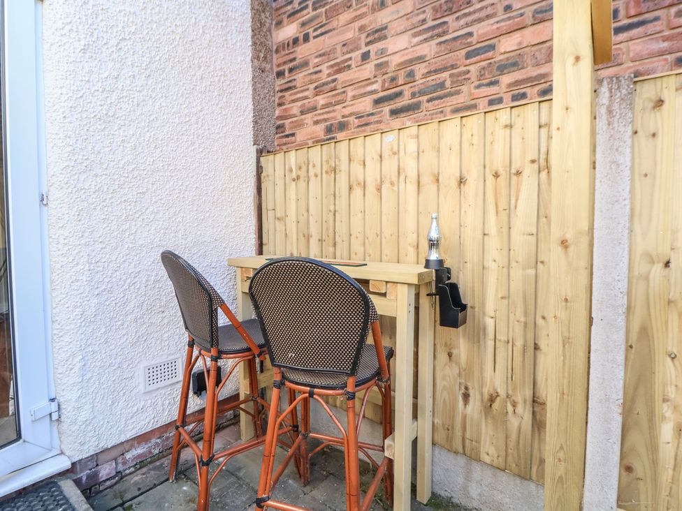 A bar table with stools in an outdoor space at 57 Broadway West Chester