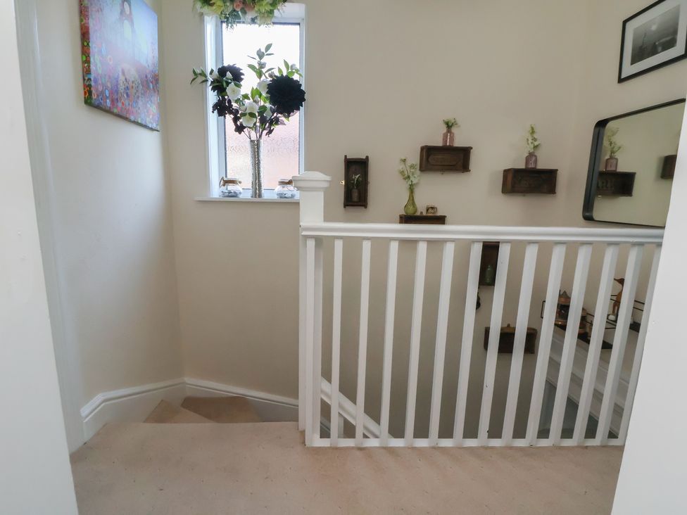 A hallway with staircase and wall decorations at 57 Broadway West Chester