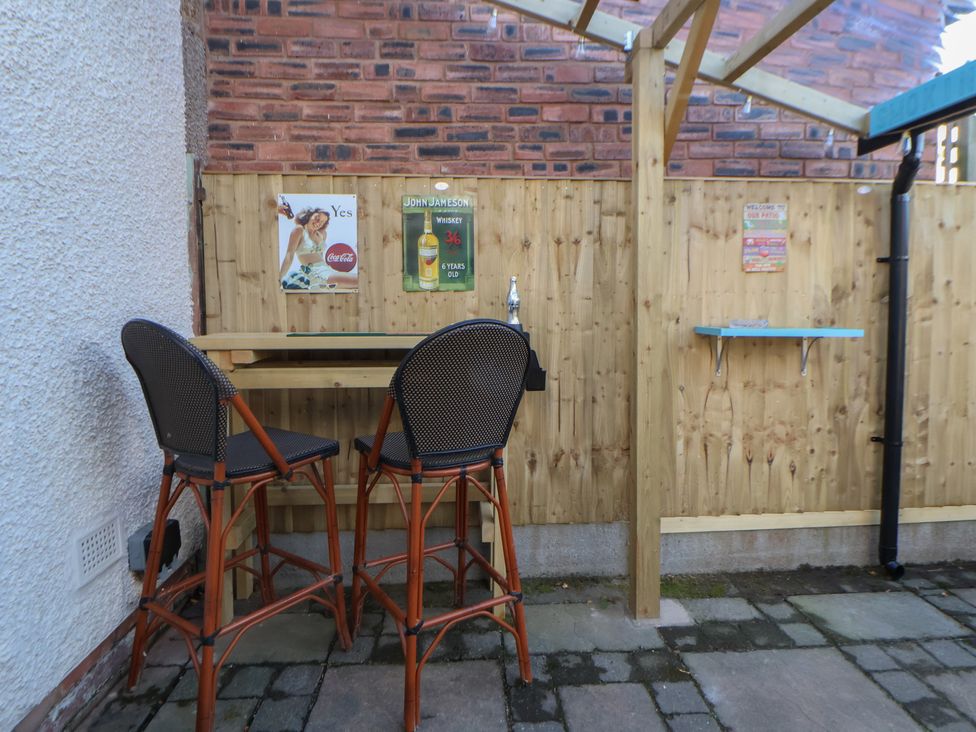 A seating area with bar stools and a table in the outdoor space at 57 Broadway West Chester