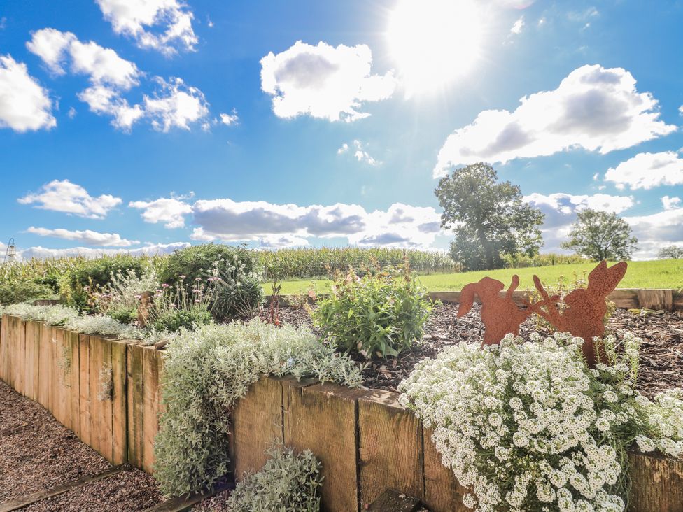 A garden with flower beds and decorative elements at Gapstile in Abbots Bromley
