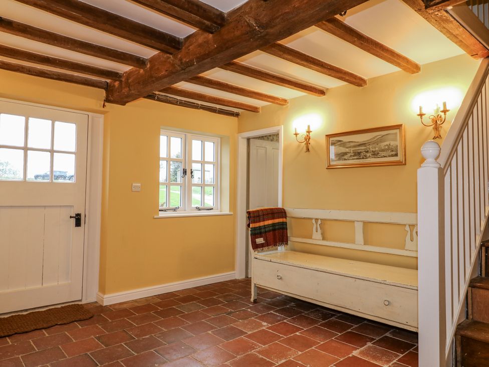 A hallway with a bench and staircase at Gapstile in Abbots Bromley