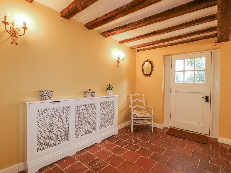 A hallway with a door and a sideboard at Gapstile in Abbots Bromley