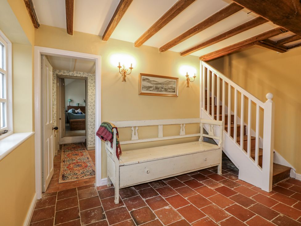 A hallway with a bench and staircase at Gapstile in Abbots Bromley