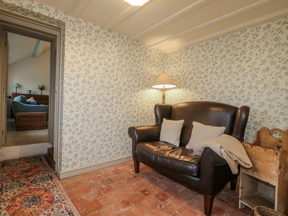 A snug area with an armchair and a lamp at Gapstile in Abbots Bromley