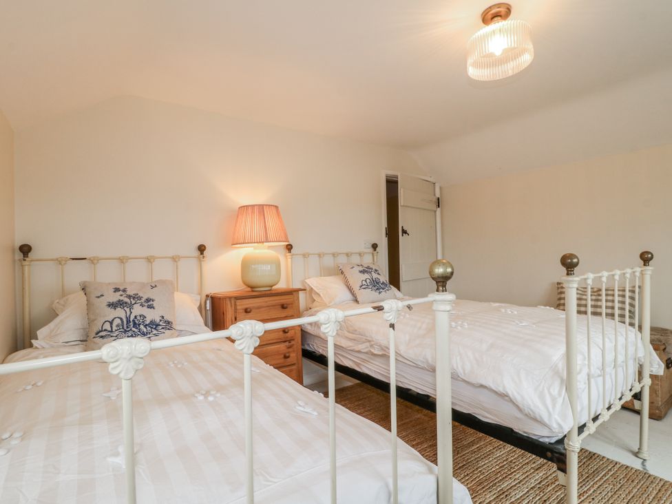 A bedroom with two beds and a lamp at Gapstile in Abbots Bromley
