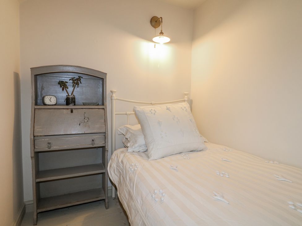 A bedroom with a bed and shelf at Gapstile in Abbots Bromley