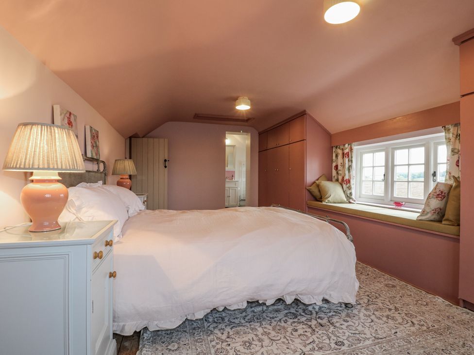 A bedroom with a bed and a window seat at Gapstile in Abbots Bromley