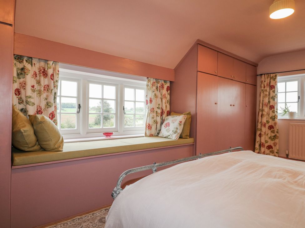 A bedroom with a window seat and bed at Gapstile in Abbots Bromley