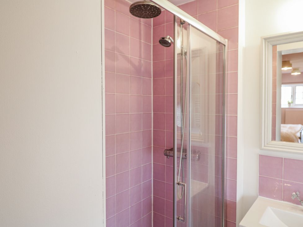 A shower with pink tiles and a sink at Gapstile in Abbots Bromley