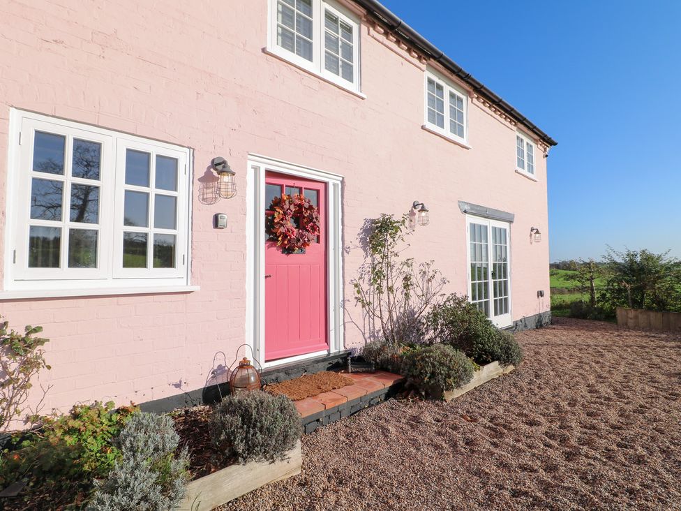 A pink exterior wall with a door and windows at Gapstile in Abbots Bromley