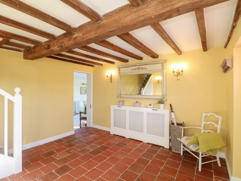 A hallway with stairs and a console table at Gapstile in Abbots Bromley