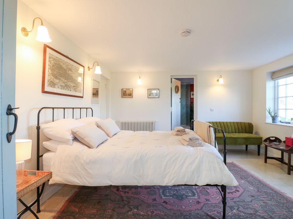 A bedroom with a bed and sofa at Gapstile in Abbots Bromley