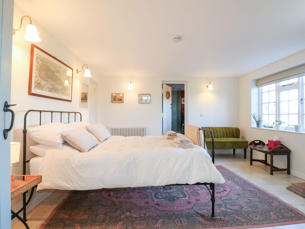 A bedroom with a bed and a sofa at Gapstile in Abbots Bromley