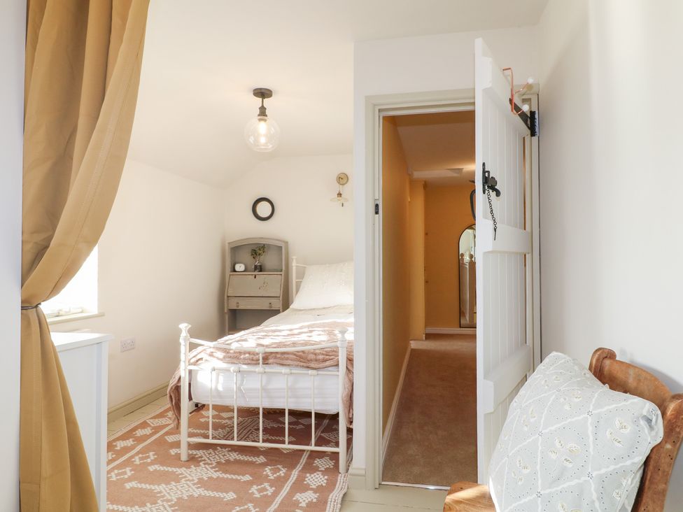 A bedroom with a bed and mirror at Gapstile in Abbots Bromley