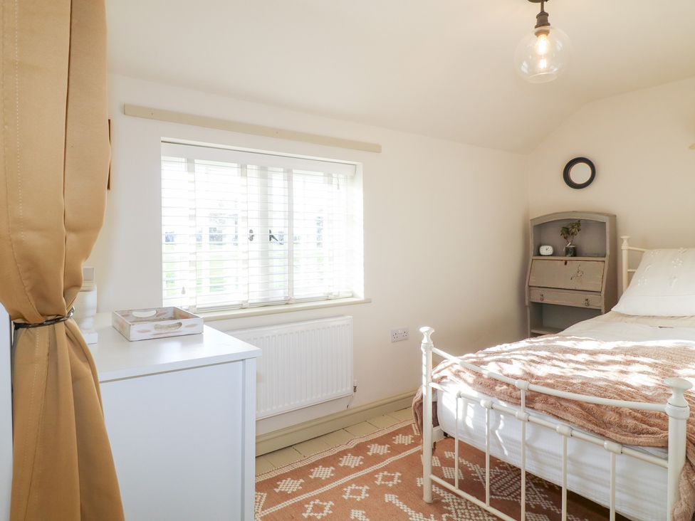 A bedroom with a bed and cabinet at Gapstile in Abbots Bromley