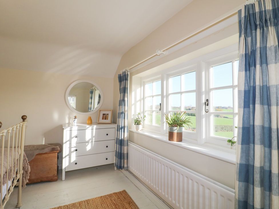 A bedroom with a bed, dresser, and window at Gapstile in Abbots Bromley