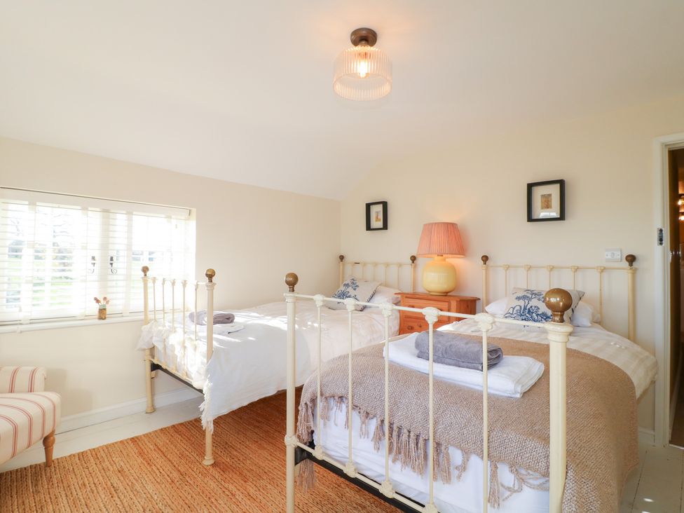 A bedroom with two beds and a lamp at Gapstile in Abbots Bromley