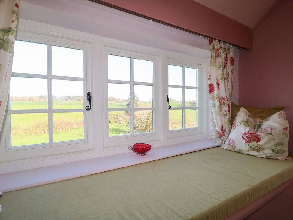 A window seat with cushions overlooking a field at Gapstile in Abbots Bromley