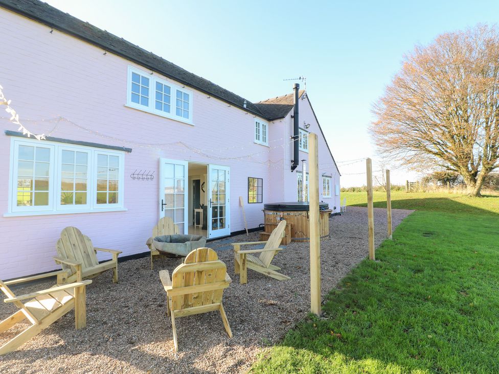 An outdoor area with a hot tub and seating at Gapstile in Abbots Bromley