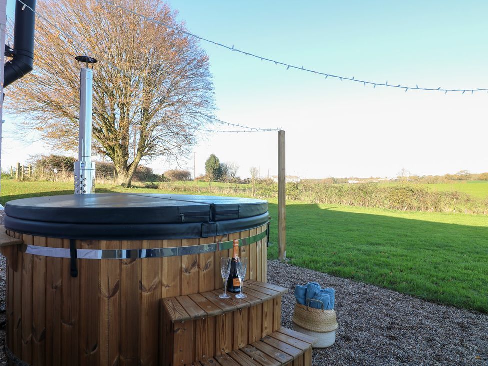 An outdoor area with a hot tub and champagne at Gapstile in Abbots Bromley