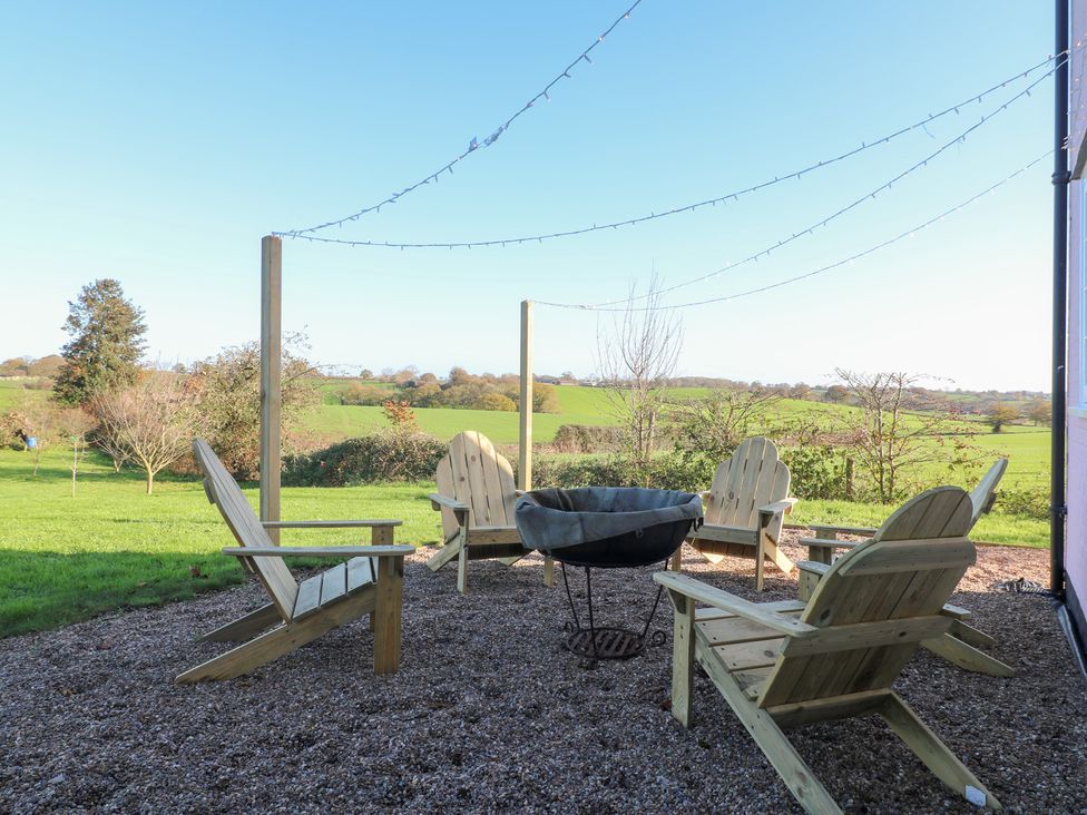 An outdoor seating area with chairs and a fire pit at Gapstile in Abbots Bromley