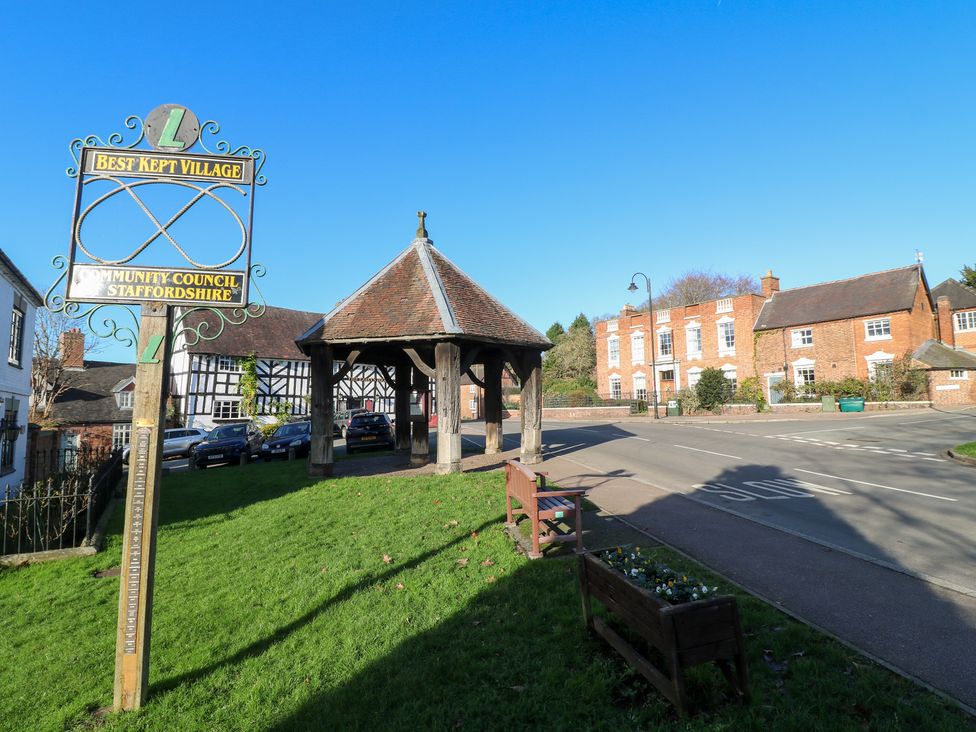 A village scene with a sign and gazebo at Gapstile in Abbots Bromley