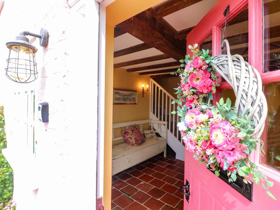 An entrance hall with a sofa and staircase at Gapstile in Abbots Bromley