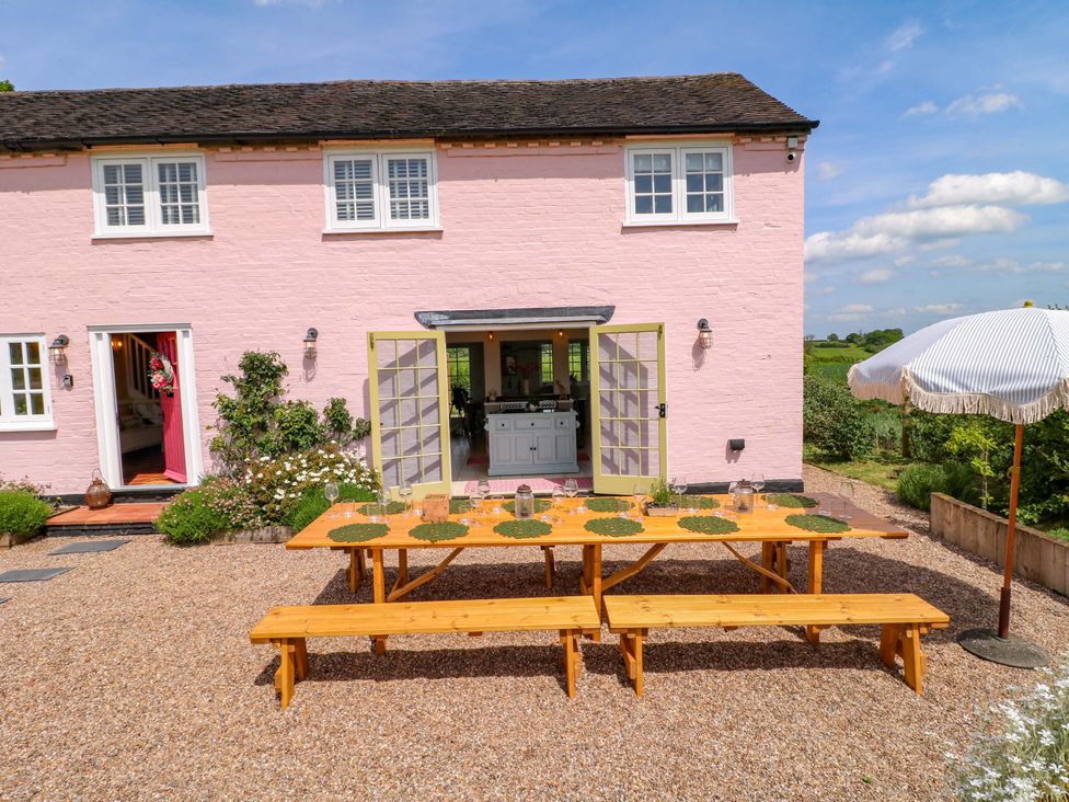An outdoor area with a table and benches at Gapstile in Abbots Bromley