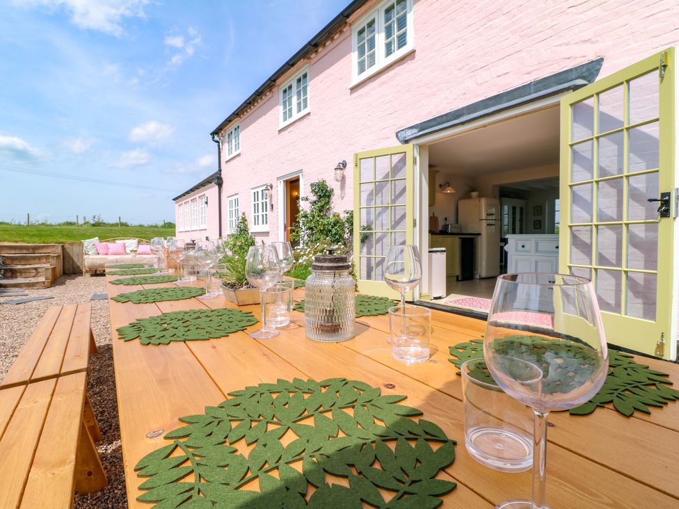 An outdoor dining area with a table set for a meal at Gapstile in Abbots Bromley