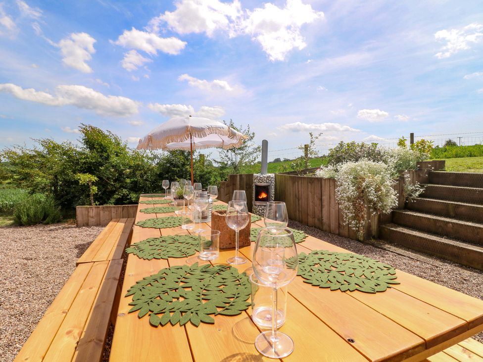 An outdoor dining setup with a table and glasses at Gapstile in Abbots Bromley