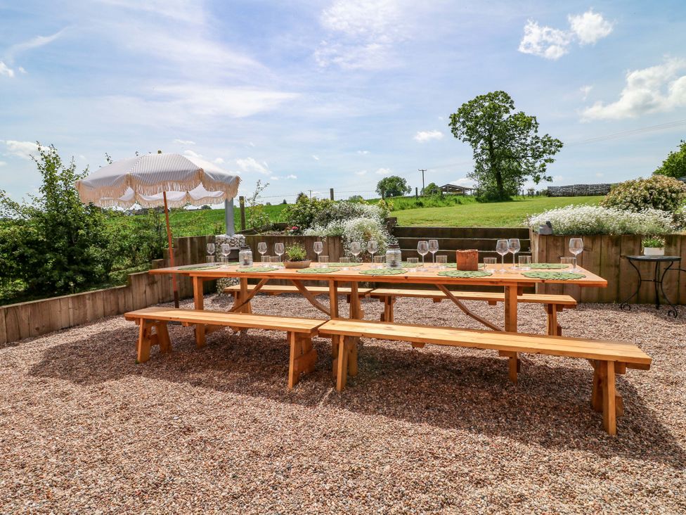A dining setup with a wooden table and benches at Gapstile in Abbots Bromley