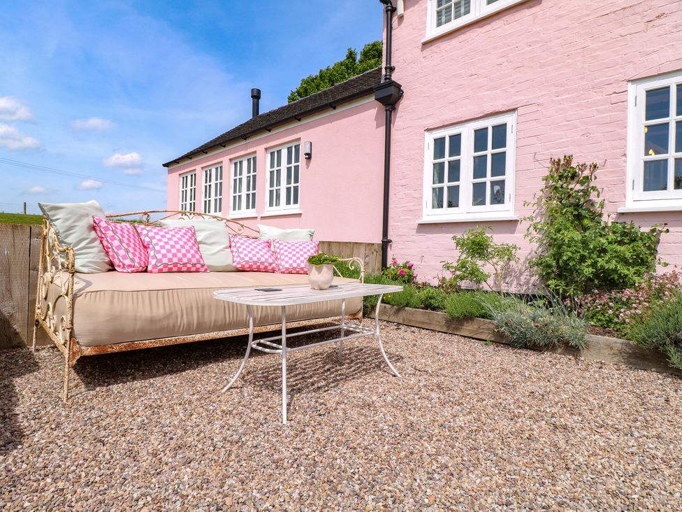 A garden with a sofa and table at Gapstile in Abbots Bromley